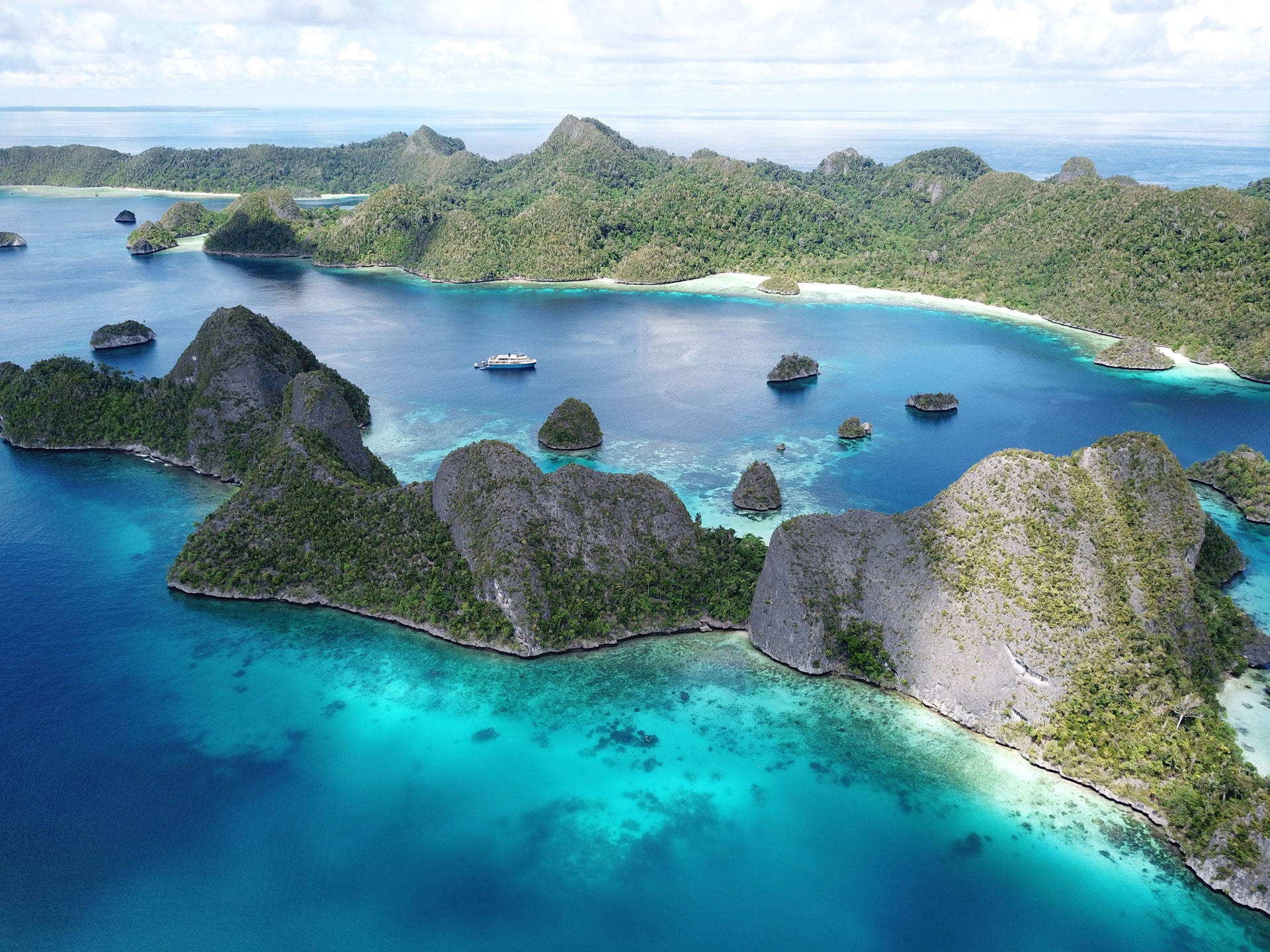 Kudanil Explorer anchored in beautiful bay in Raja Ampat National Park Indonesia